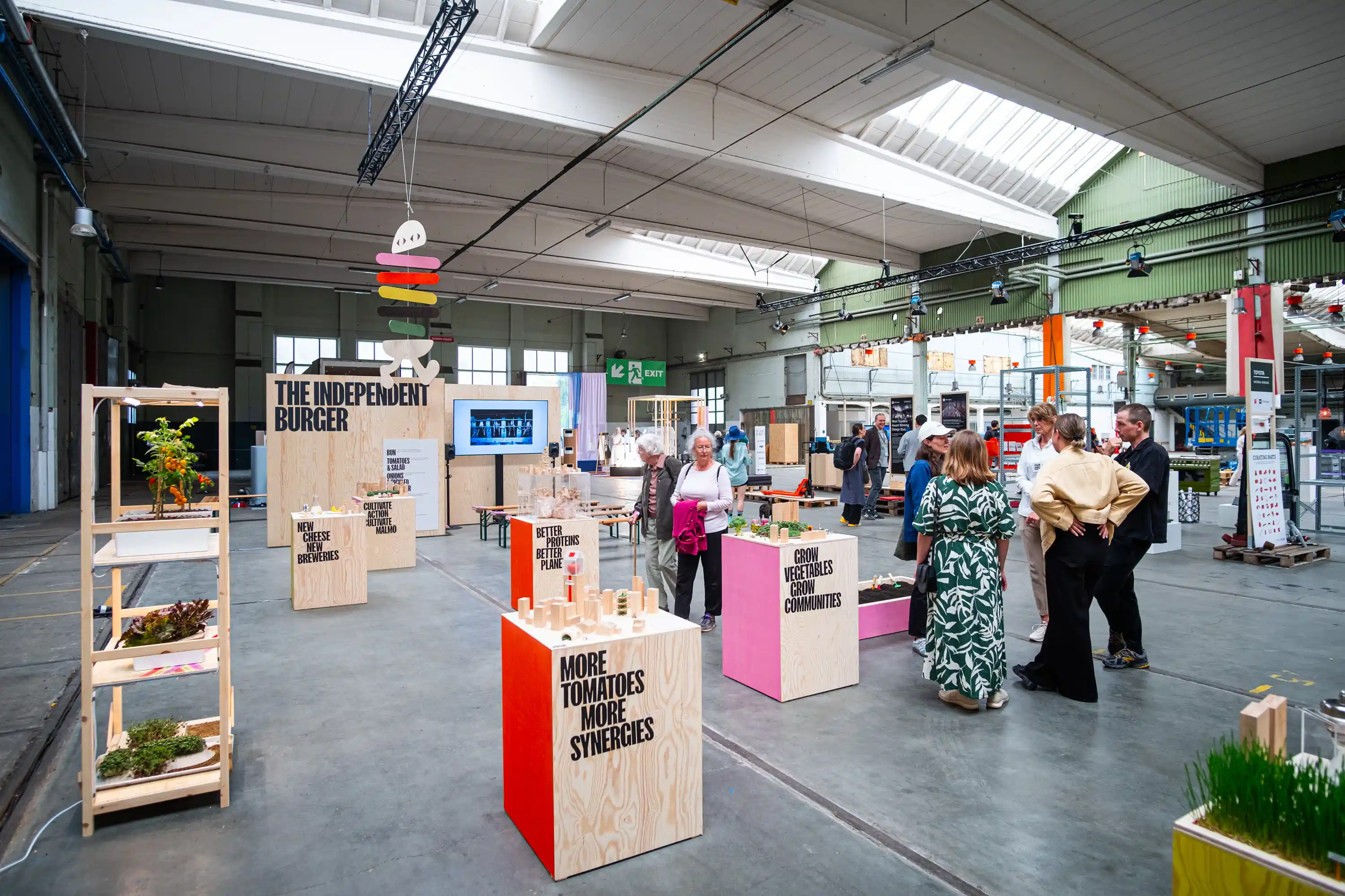 An exhibition hall with people looking at the Urban Food Revolution exhibit.