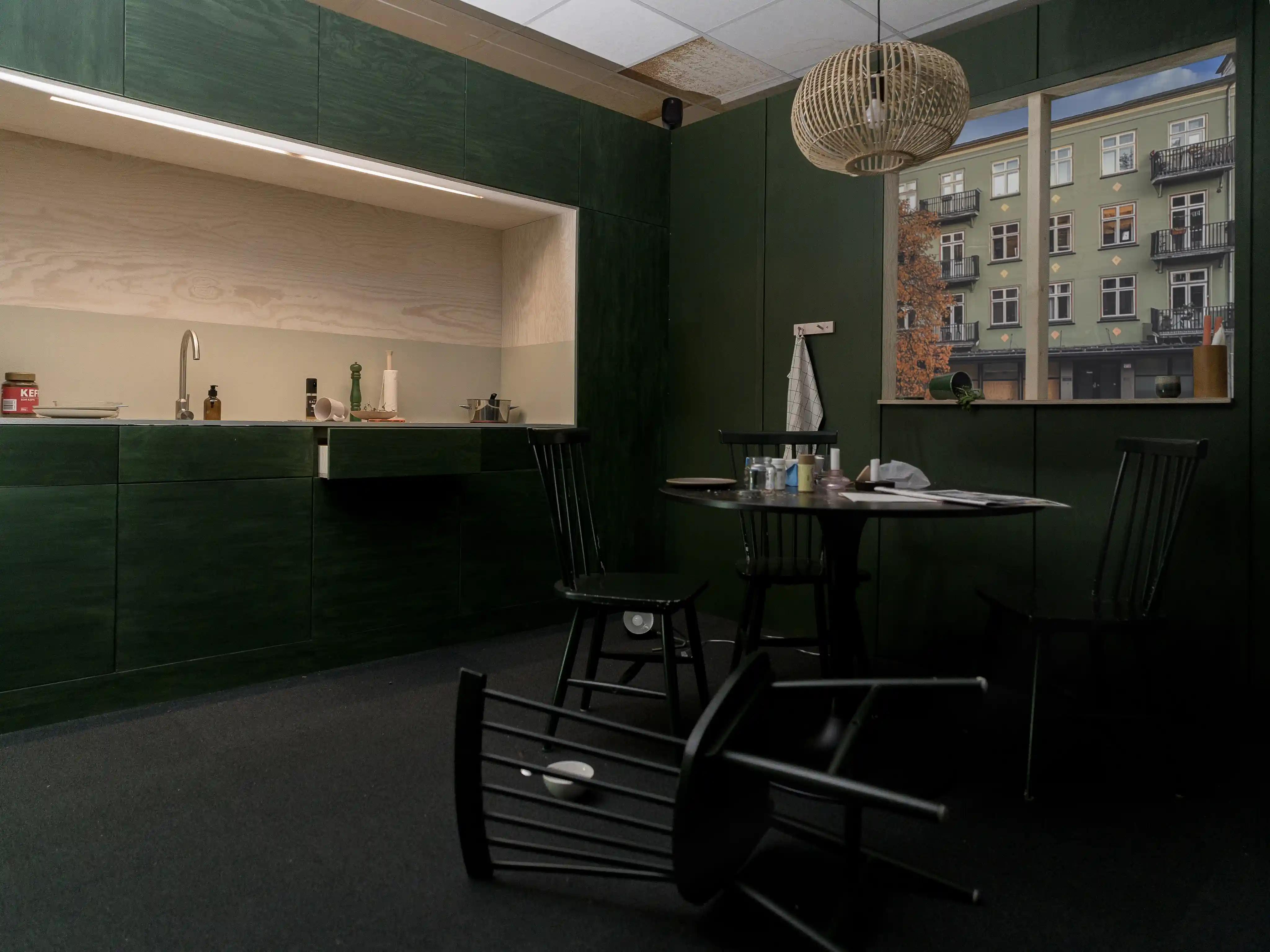 A kitchen in disarray with a dining chair laying on the floor.